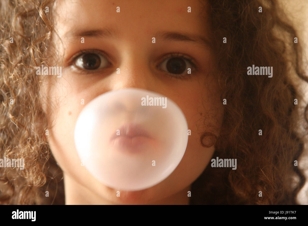 Little girl blowing bubbles from bubble gum Stock Photo