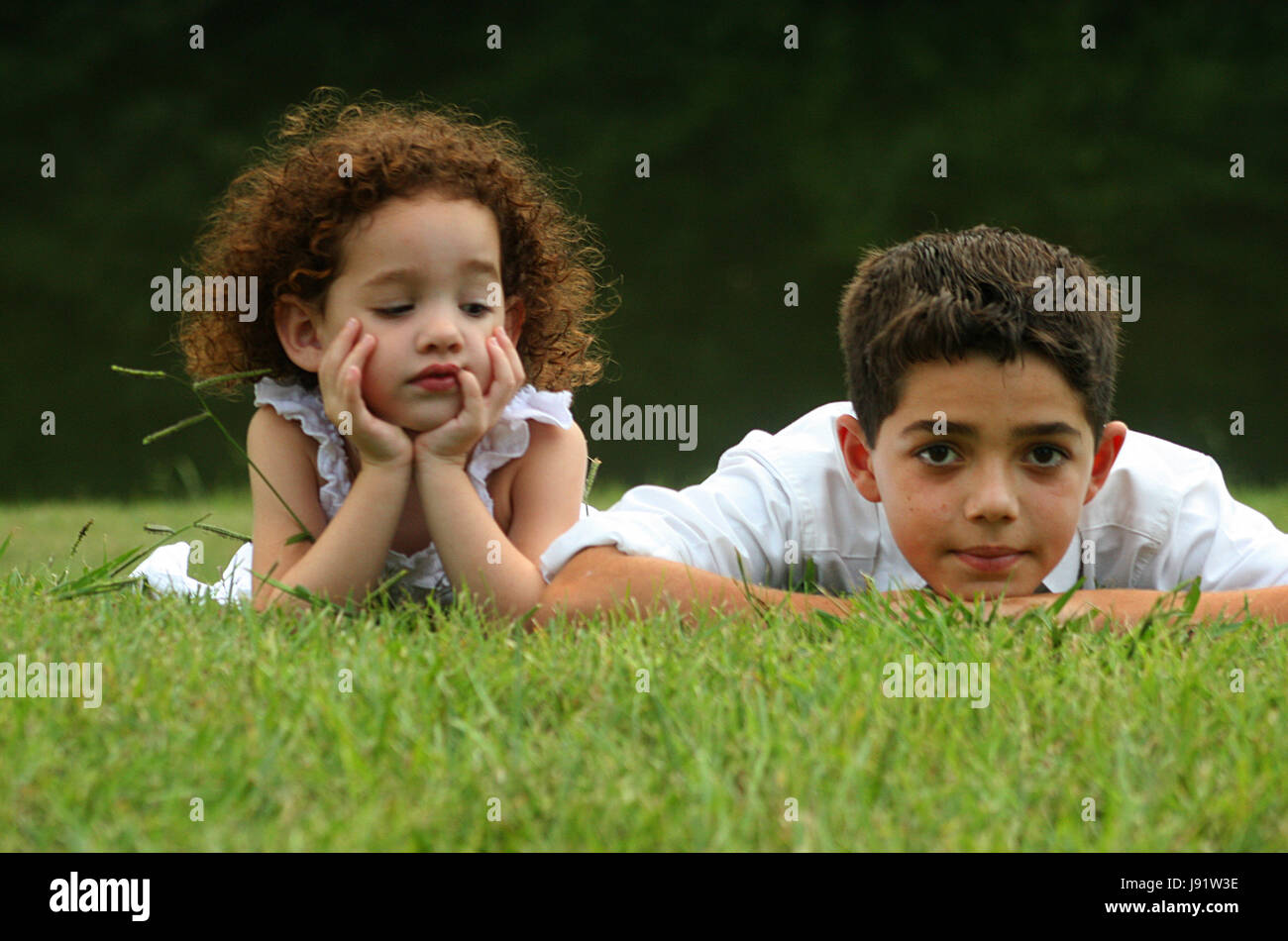 Brother and sister laying on the grass Stock Photo - Alamy