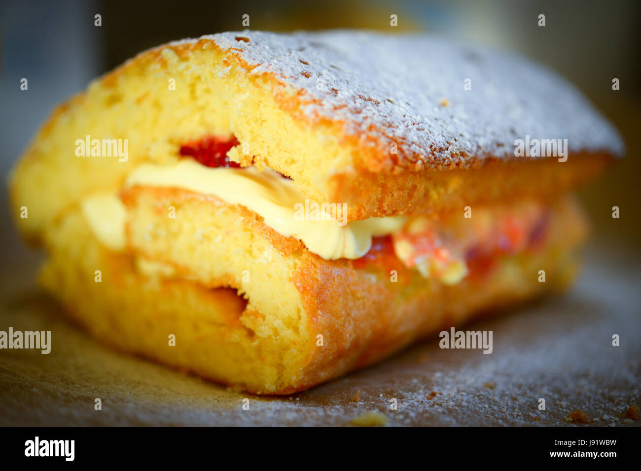 Home cooked fresh cream and raspberry  roulade with a dusting of icing sugar. Stock Photo