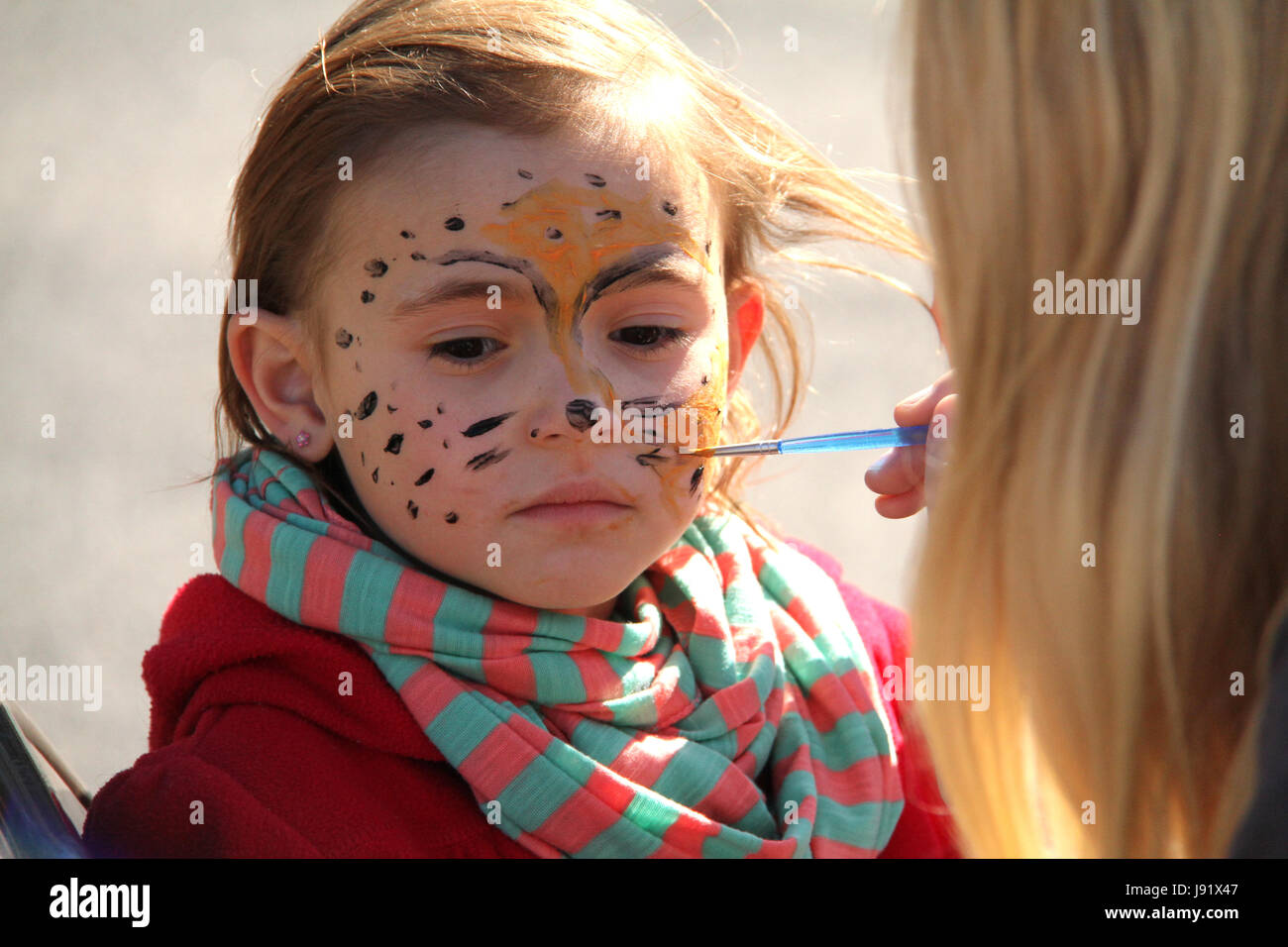 Close up of girl's face during face paint session Stock Photo