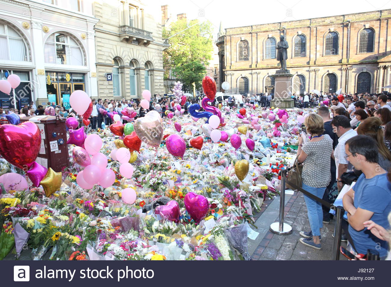 People pay tribute to the victims of the Manchester bombing in St Ann's Square at a memorial of flowers and other objects Credit: reallifephotos/Alamy Stock Photo