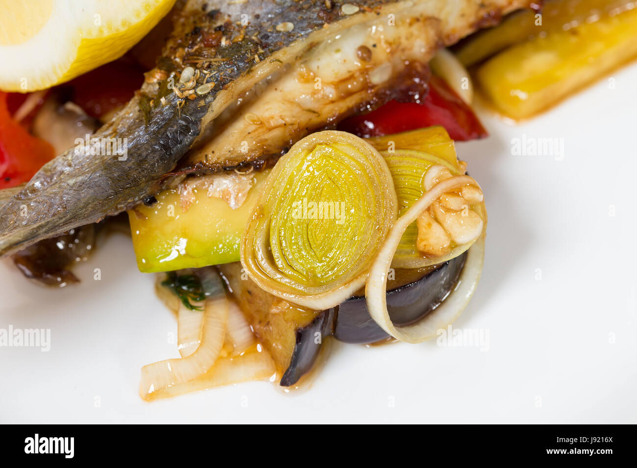 Grilled vegetables as a garnish for baked dorado. Macro. Photo can be used as a whole background. Stock Photo