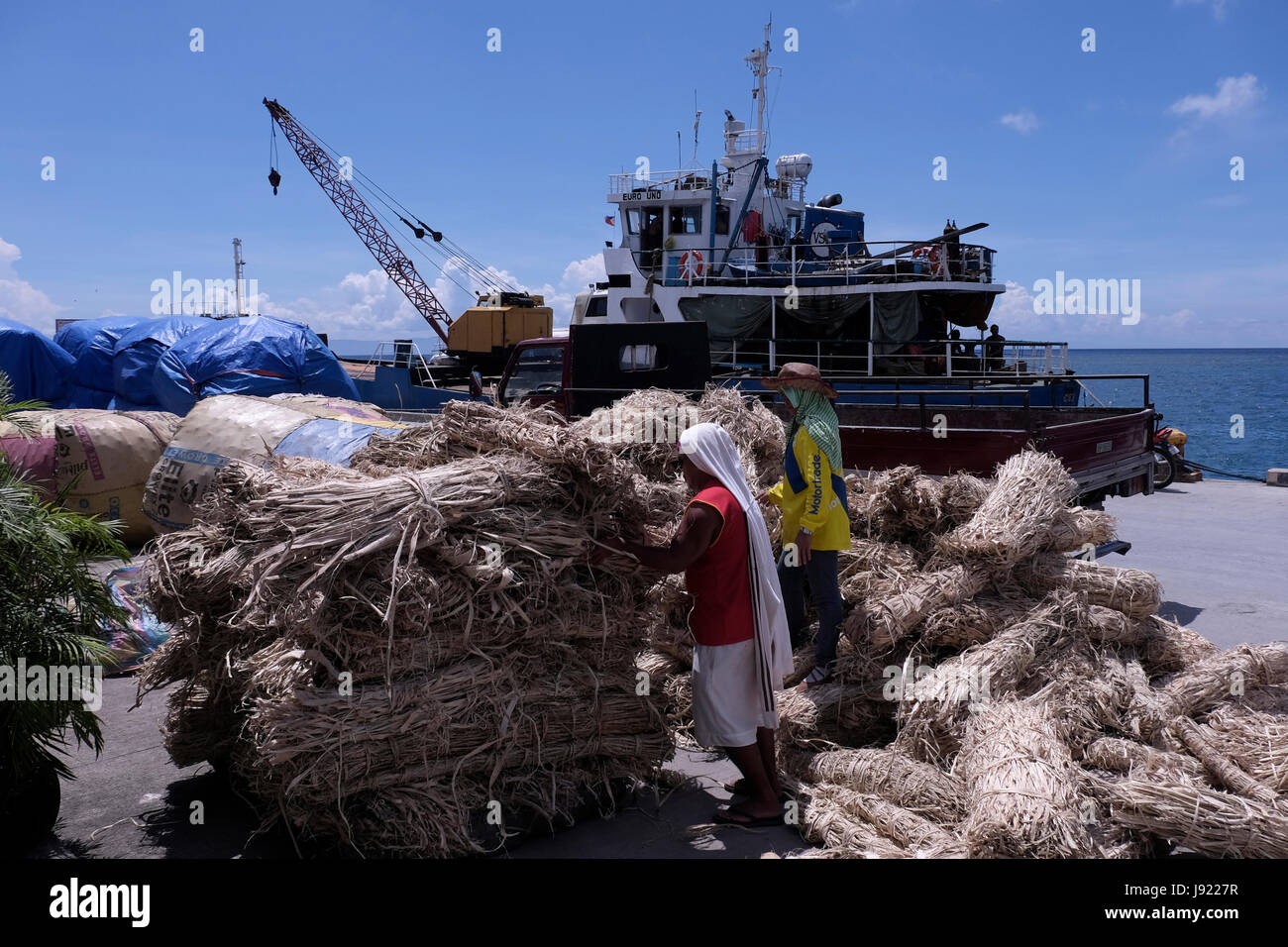 Workers at the port of the city of Siquijor at the island of Siquijor located in the Central Visayas region of the Philippines Stock Photo