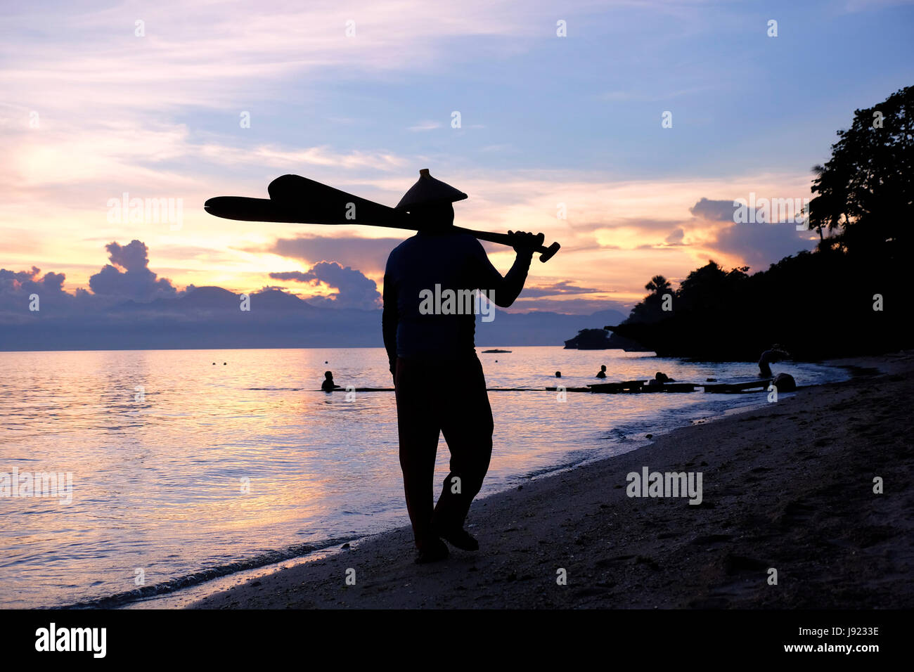 Chinese man bathing at sunset in the island of Siquijor located in the Central Visayas region of the Philippines Stock Photo