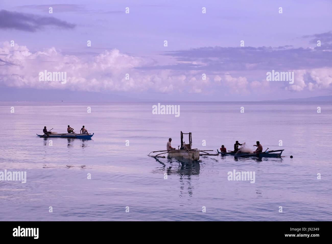Fishermen in traditional banka outrigger boats in the island of Siquijor located in the Central Visayas region of the Philippines Stock Photo