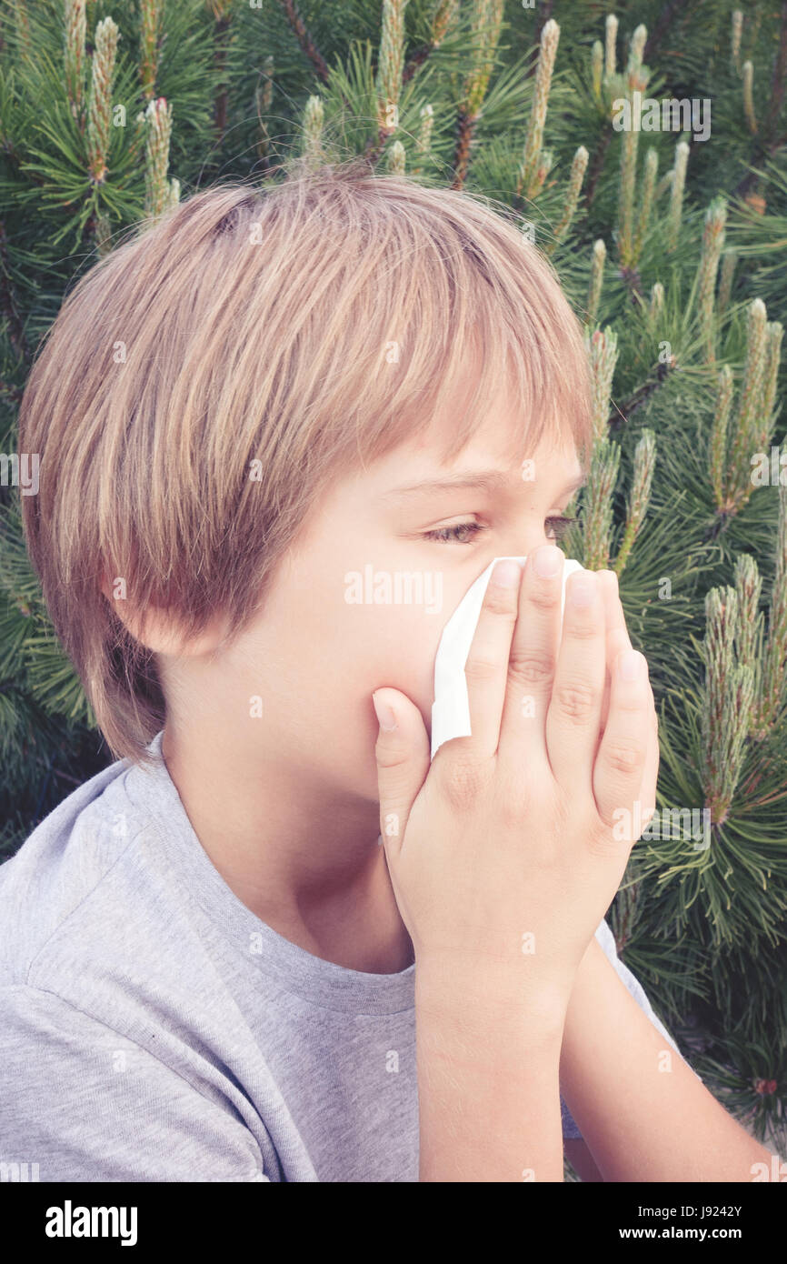 Child blowing nose with tissue paper at the park Stock Photo Alamy
