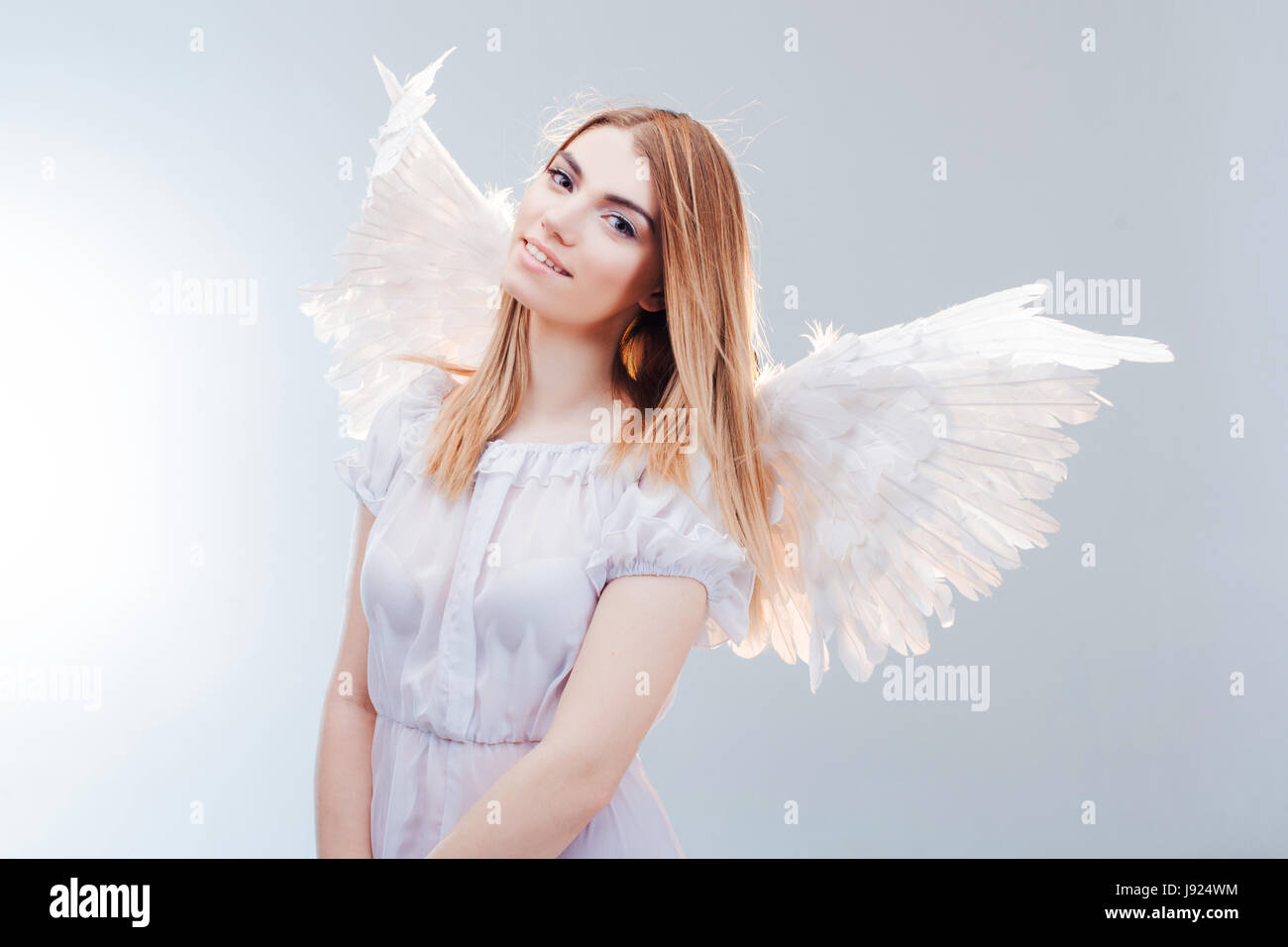 Young and wonderful blonde girl in the image of an angel with white ...