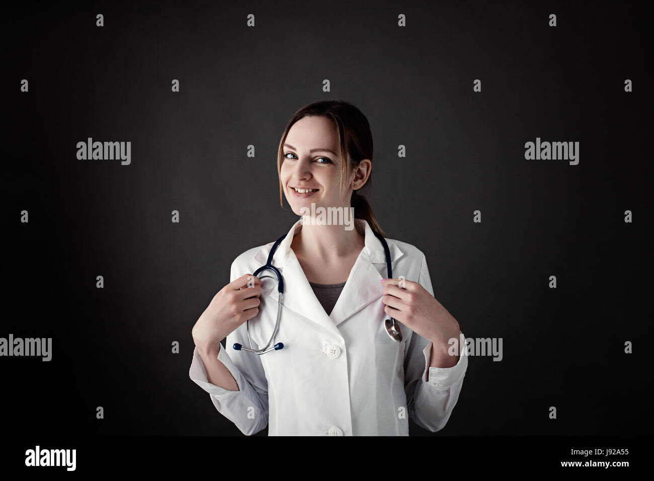 Radiology, gynecology, therapeutic or traumatology concept. Medical care or insurance concept. Female Intern hold stethoscope and smiling. phonendosco Stock Photo