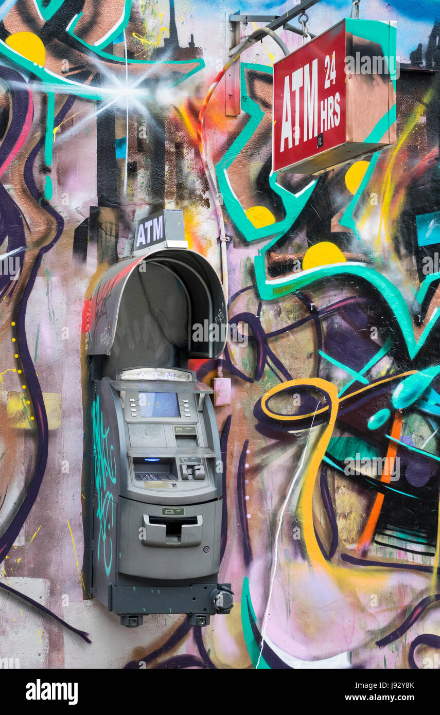 Independent ATM unit on a graffiti covered wall in New York City Stock Photo