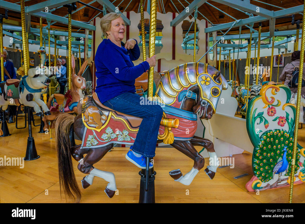 Senior citizen riding Carousel, Butchart Gardens, Brentwood Bay, Vancouver Island, British Columbia, Canada Stock Photo