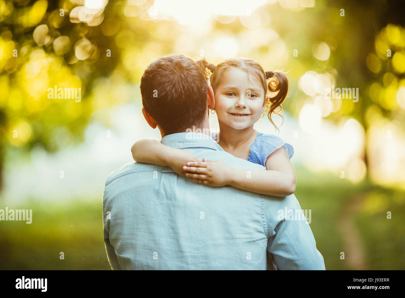 Father with his Daughter in hands walking in summer park sunset Stock ...