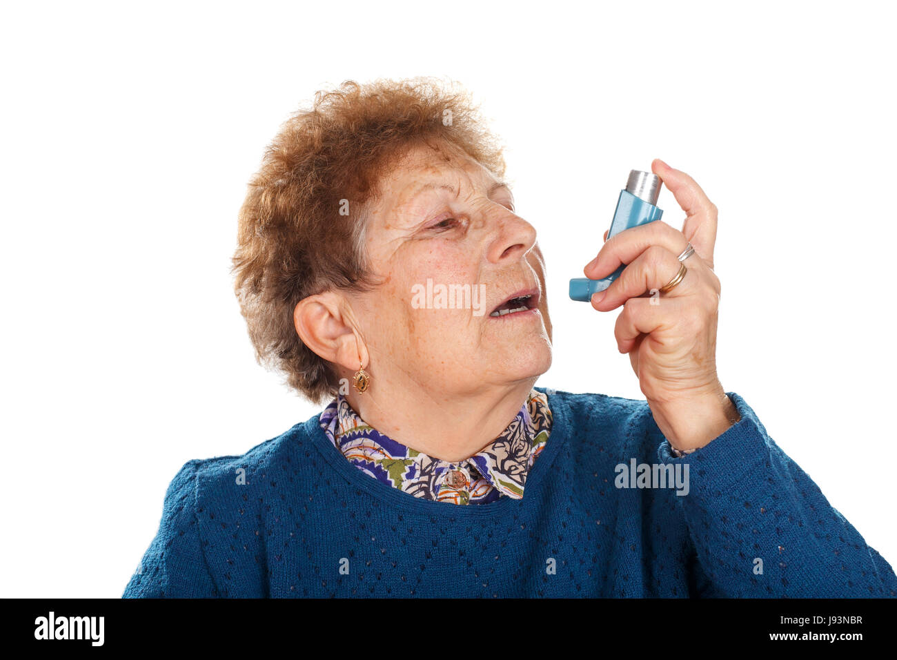Picture of an elderly woman using an inhaler beacuse of an asthma