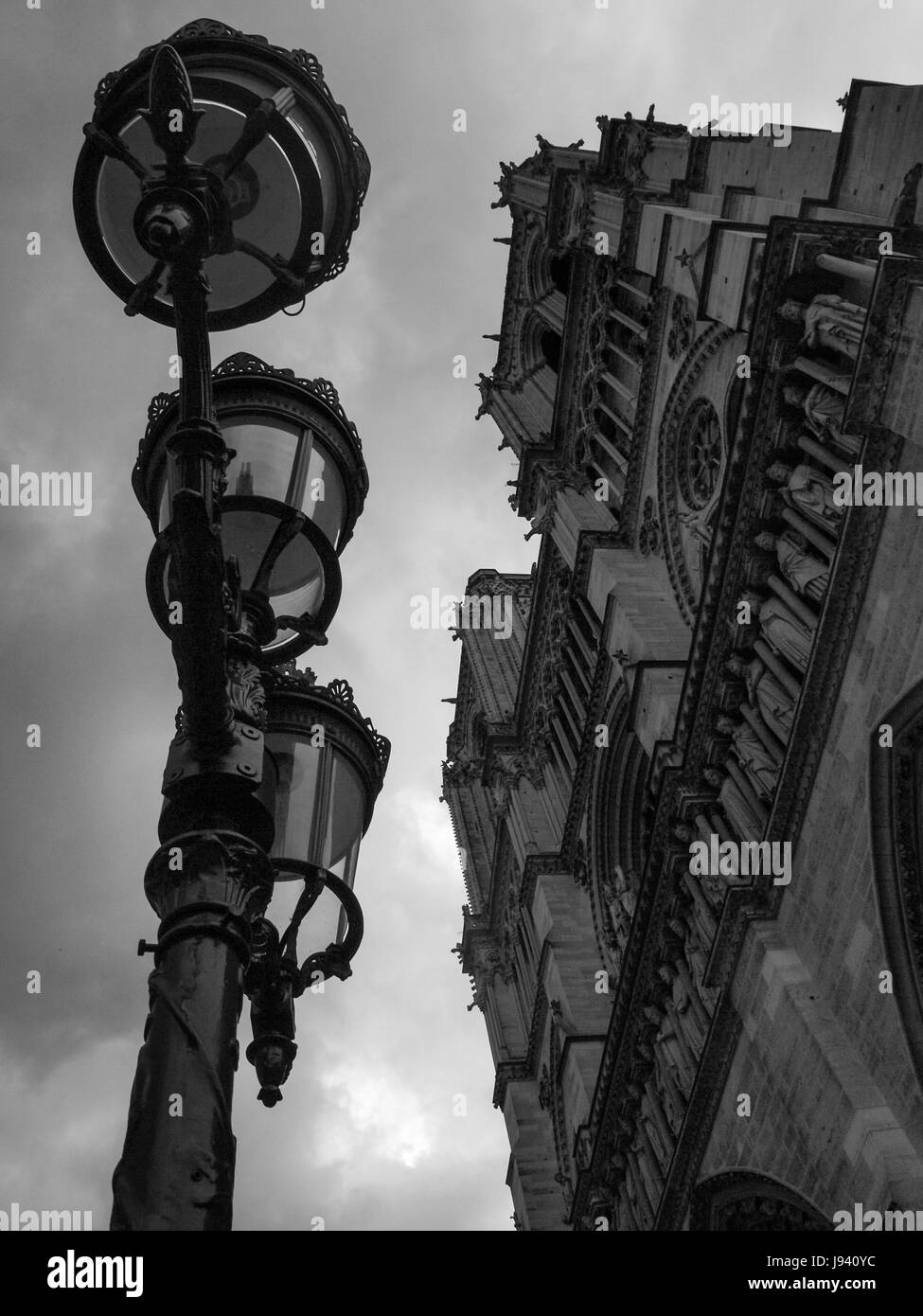 The Notre Dame cathedral, in Paris, France.  Upward shot of the notre dame including lamp post street lighting. Stock Photo