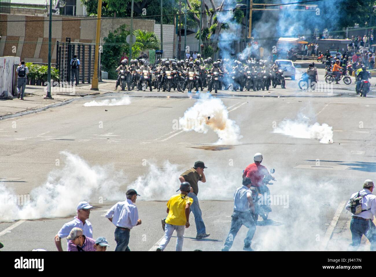 Bolivarian National Police, lashes out against protesters with tear gas in the streets near the highway. Opponents marched to the Ombudsman's Office,  Stock Photo