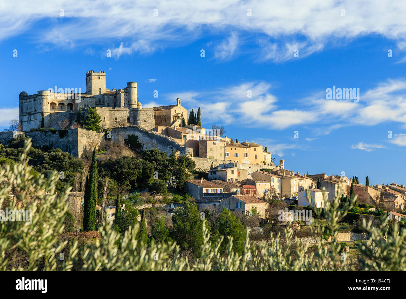 France, Vaucluse, Le Barroux, the village topped with the castle seen from an olive grove Stock Photo
