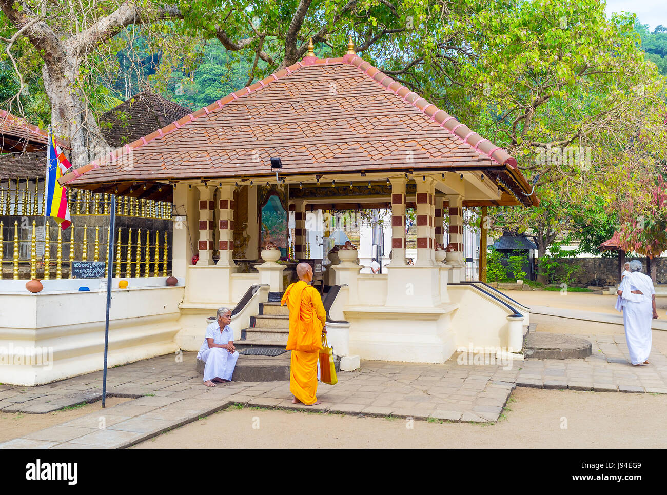 KANDY, SRI LANKA - NOVEWMBER 28, 2016: The  monk next to the small temple on the territory of Natha Devale complex, on November 28 in Kandy. Stock Photo