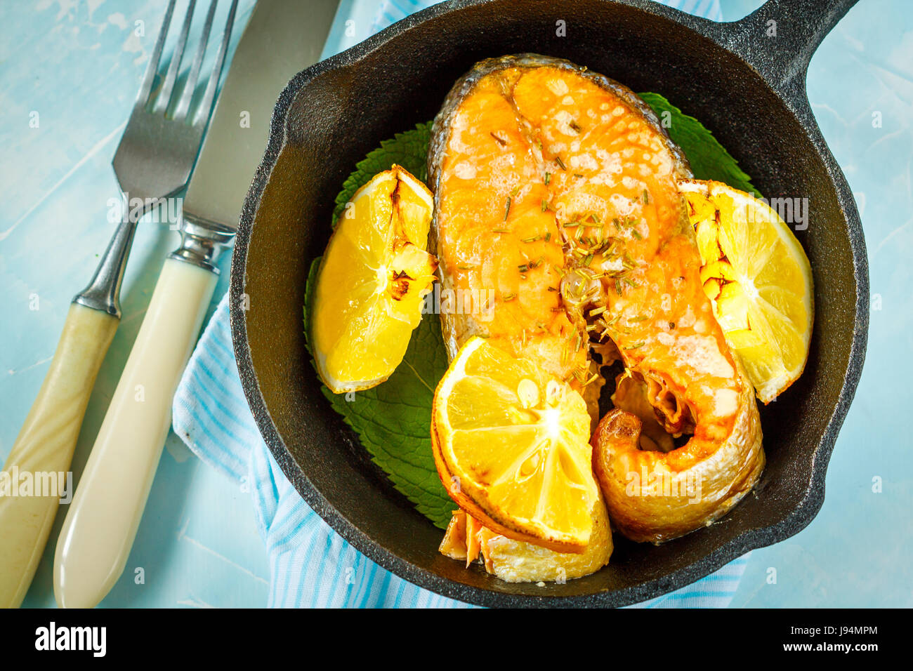 Chum baked with lemon in a cast-iron frying pan Stock Photo - Alamy