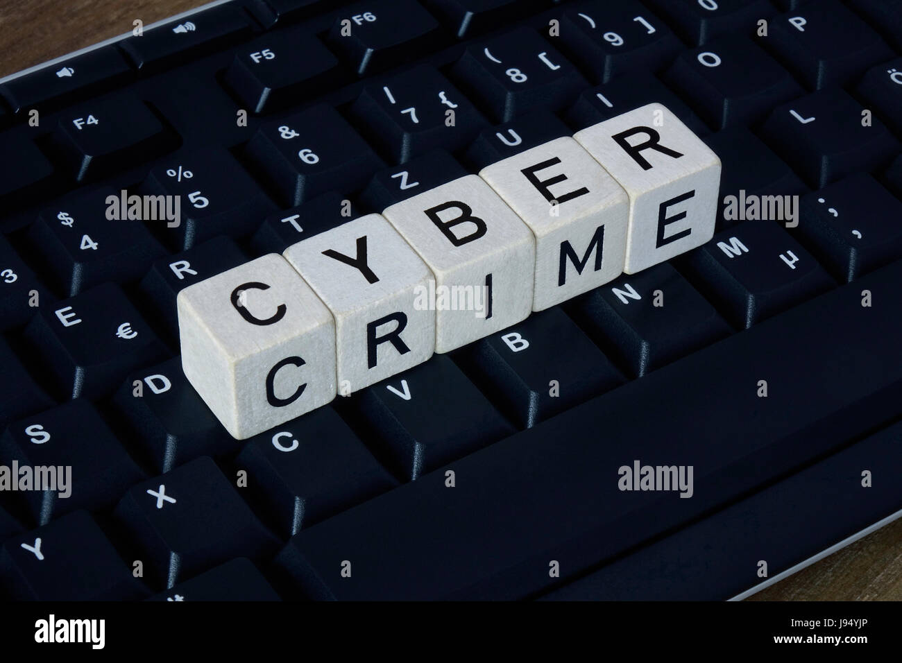 ILLUSTRATION - 'CYBER CRIME' spelt out with letter-dice lying on a computer keyboard. Taken 18.02.2017. The term computer crime or cyber crime relates to crimes that use or exploit information or communication technology, or attempted attacks on these. - NO WIRE SERVICE - Photo: Sascha Steinach/dpa-Zentralbild/dpa | usage worldwide Stock Photo
