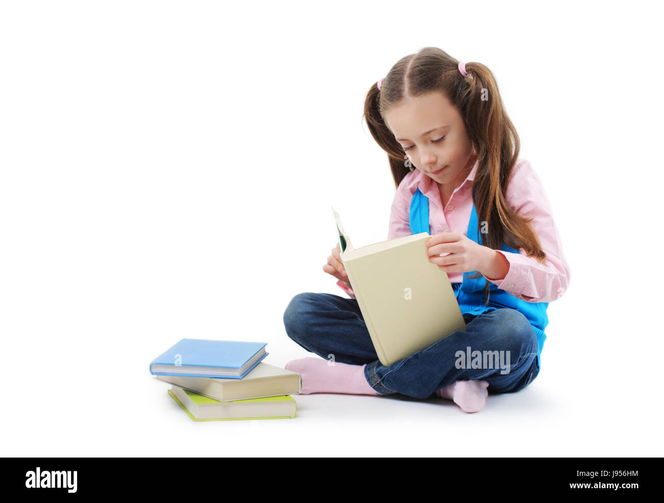 Schoolgirl reading a book on white background Stock Photo - Alamy
