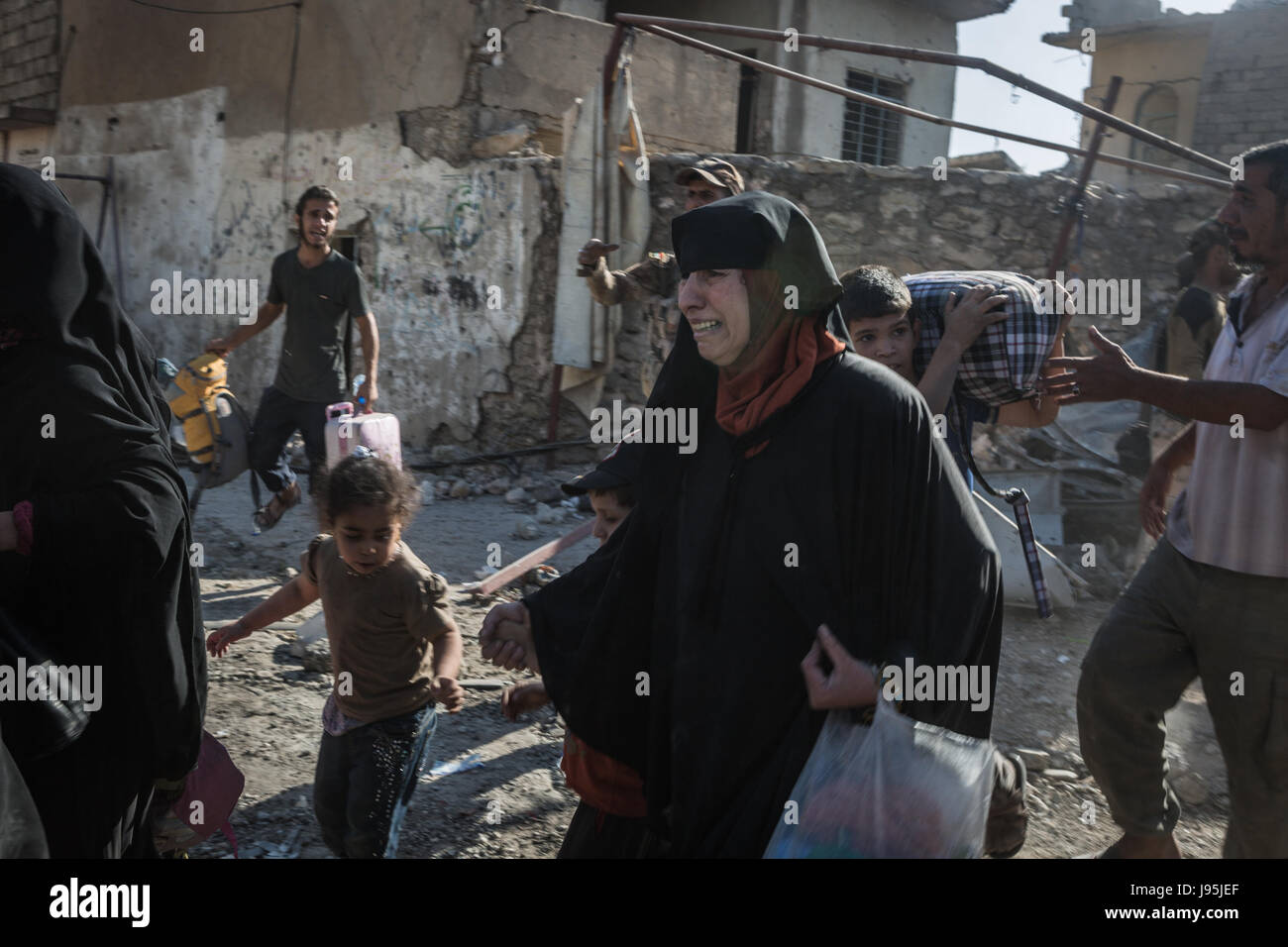 Civilians flee heavy fighting between the Iraqi army and terrorist group Islamic State (IS) in Al-Zinjili, west Mosul, Iraq, 4 June 2017. Photo: Andrea DiCenzo/dpa Stock Photo