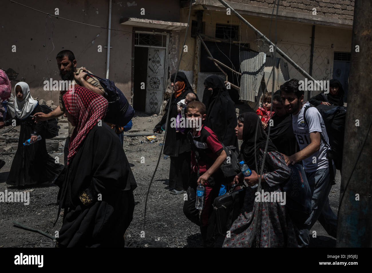 Civilians flee heavy fighting between the Iraqi army and terrorist group Islamic State (IS) in Al-Zinjili, west Mosul, Iraq, 4 June 2017. Photo: Andrea DiCenzo/dpa Stock Photo