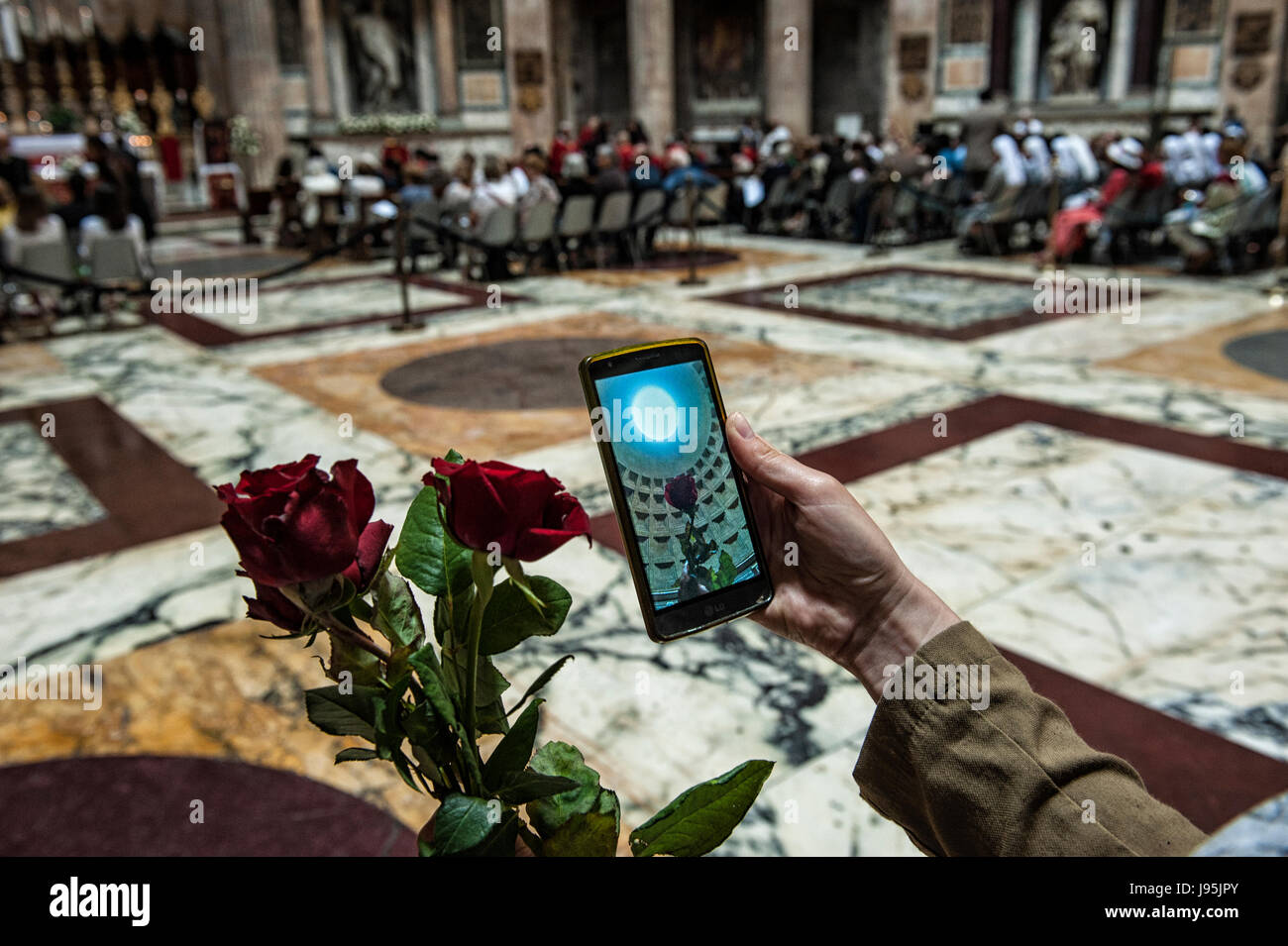 Rome, Italy. 04th June, 2017. A girl watches a photo made with her cellular before the throw of the red roses in Pantheon of Rome, Italy, in the Pentecost day Credit: Realy Easy Star/Alamy Live News Stock Photo