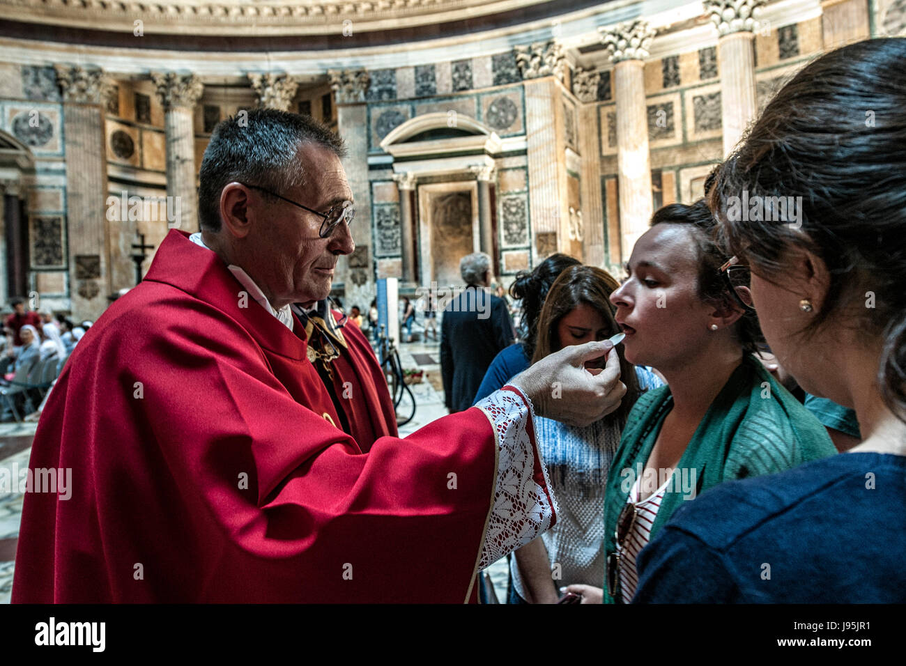 Rome, Italy. 04th June, 2017. A priest distributes the Eucharist to the participants of the Pentecost missa in Pantheon of Rome, Italy, just before the final throw of the red roses Credit: Realy Easy Star/Alamy Live News Stock Photo