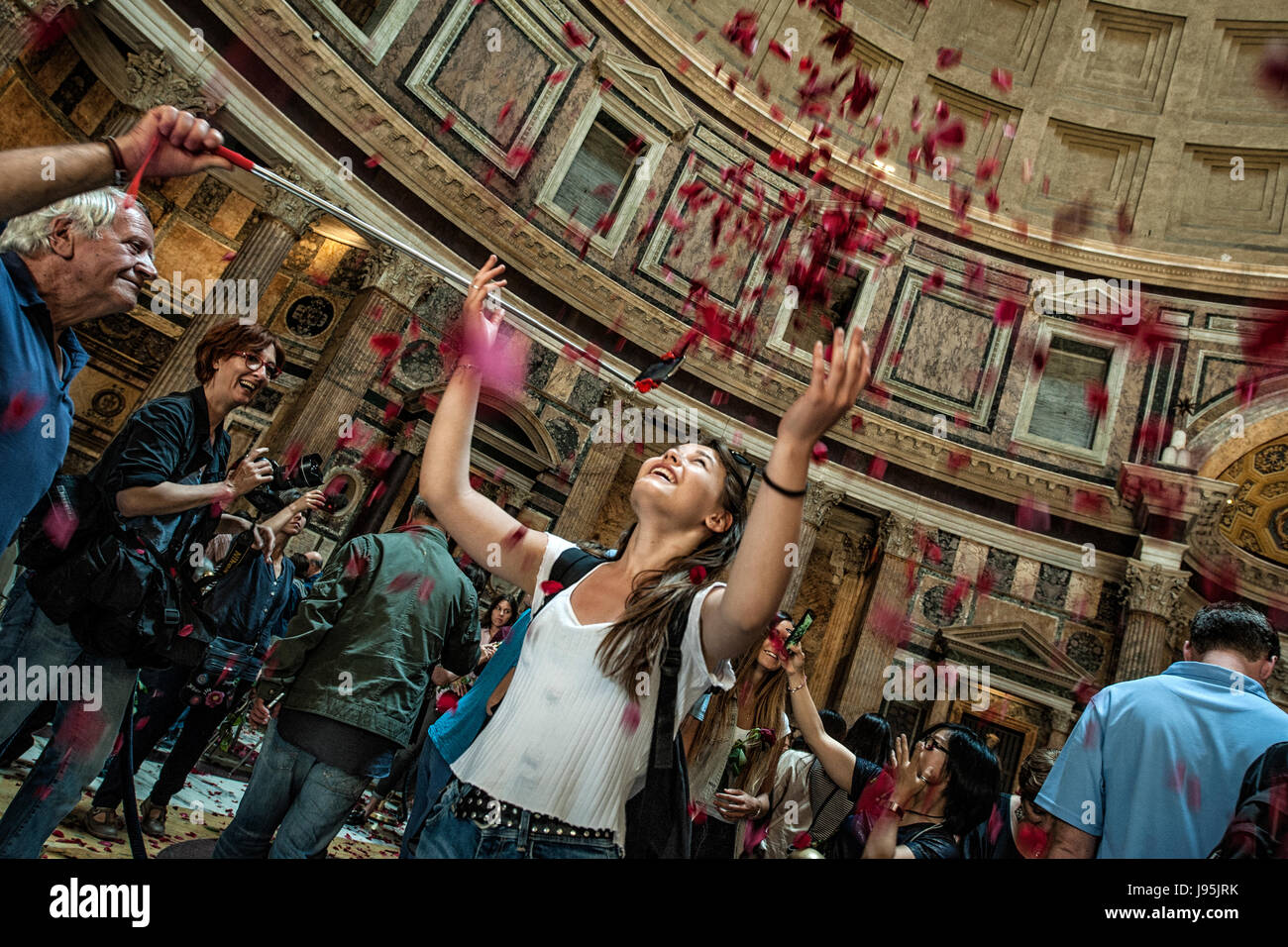 Rome, Italy. 04th June, 2017. A girl throws in the air the red roses fallen from the hole of the dome of Pantheon of Rome, Italy, after the Pentecost missa Credit: Realy Easy Star/Alamy Live News Stock Photo