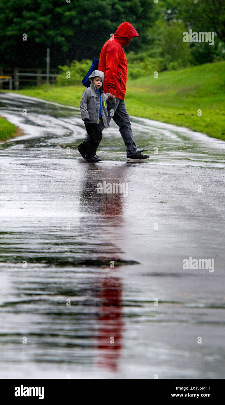 Bolton, Lancashire, UK. 05th June, 2017. Very soggy walk to school after the half term holidays in Leverhulme Park, Bolton, Lancashire, UK. Torrential rain lashes the North West of England at the start of June. Picture by Paul Heyes, Monday June 05, 2017. Credit: Paul Heyes/Alamy Live News Stock Photo