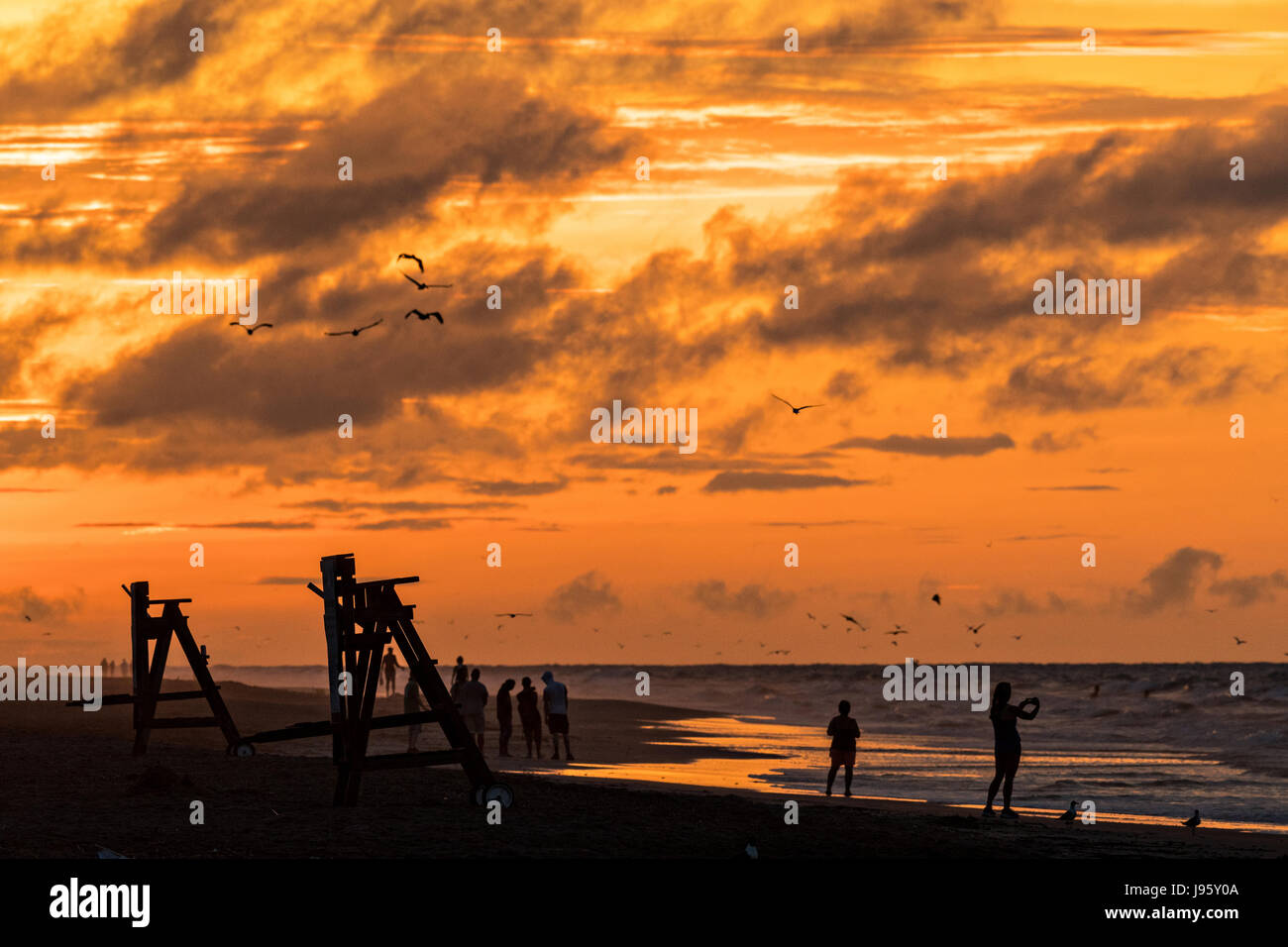 South Carolina, USA. 5th Jun, 2017. People gather along the beach to watch the sunrise on a cloudy morning June 5, 2017 in Folly Beach, South Carolina. Folly Beach is a quirky beach community outside Charleston known to locals as the Edge of America. Credit: Planetpix/Alamy Live News Stock Photo