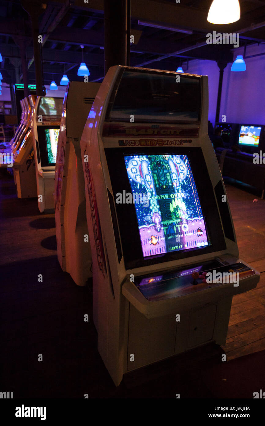 Various collection of arcades. Games being refurbished and fixed, retro consoles, modern games, pinball. What was obsolete, is now considered classic Stock Photo