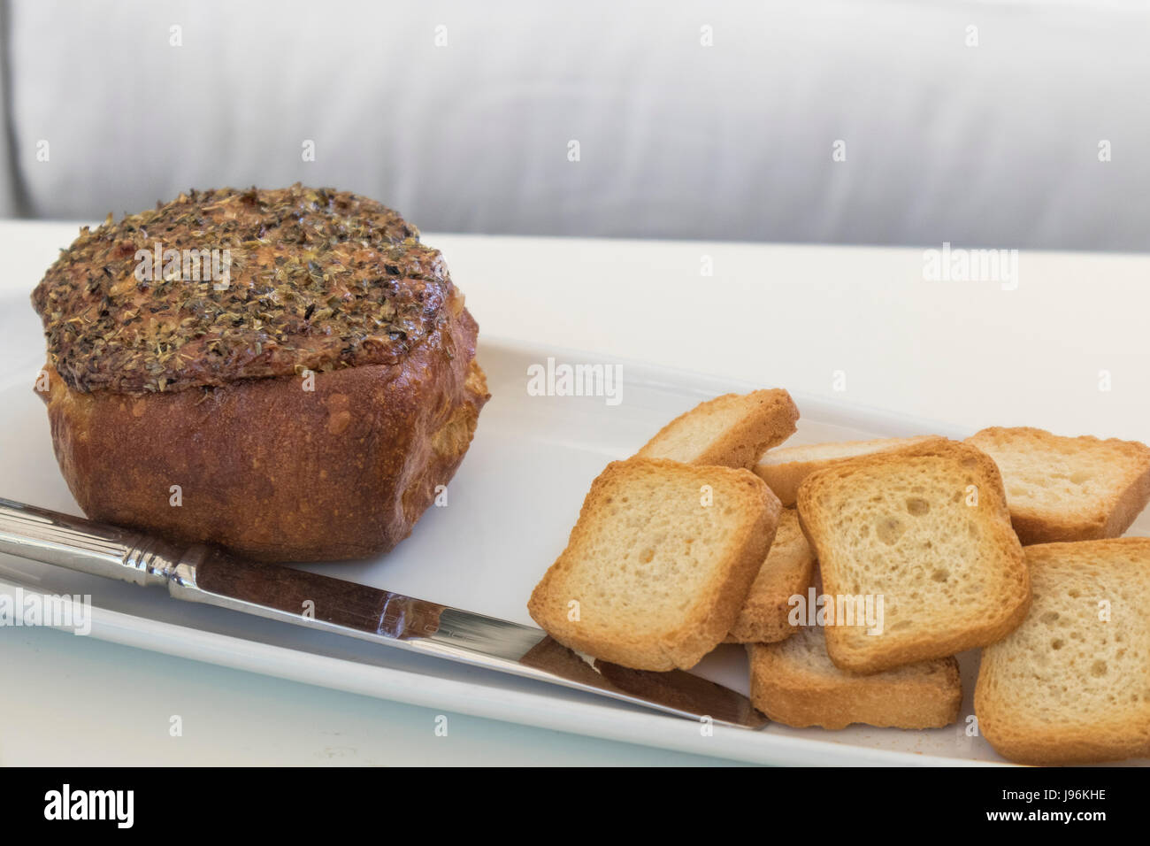Cheese gratin stuffed with ham and accompanied with toasts, gormet dish Stock Photo