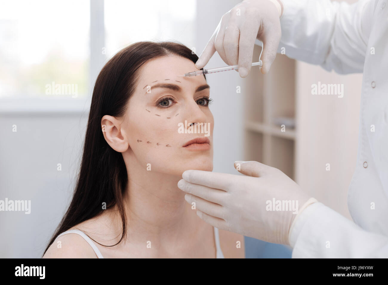 Graceful young lady trusting her face to professional Stock Photo