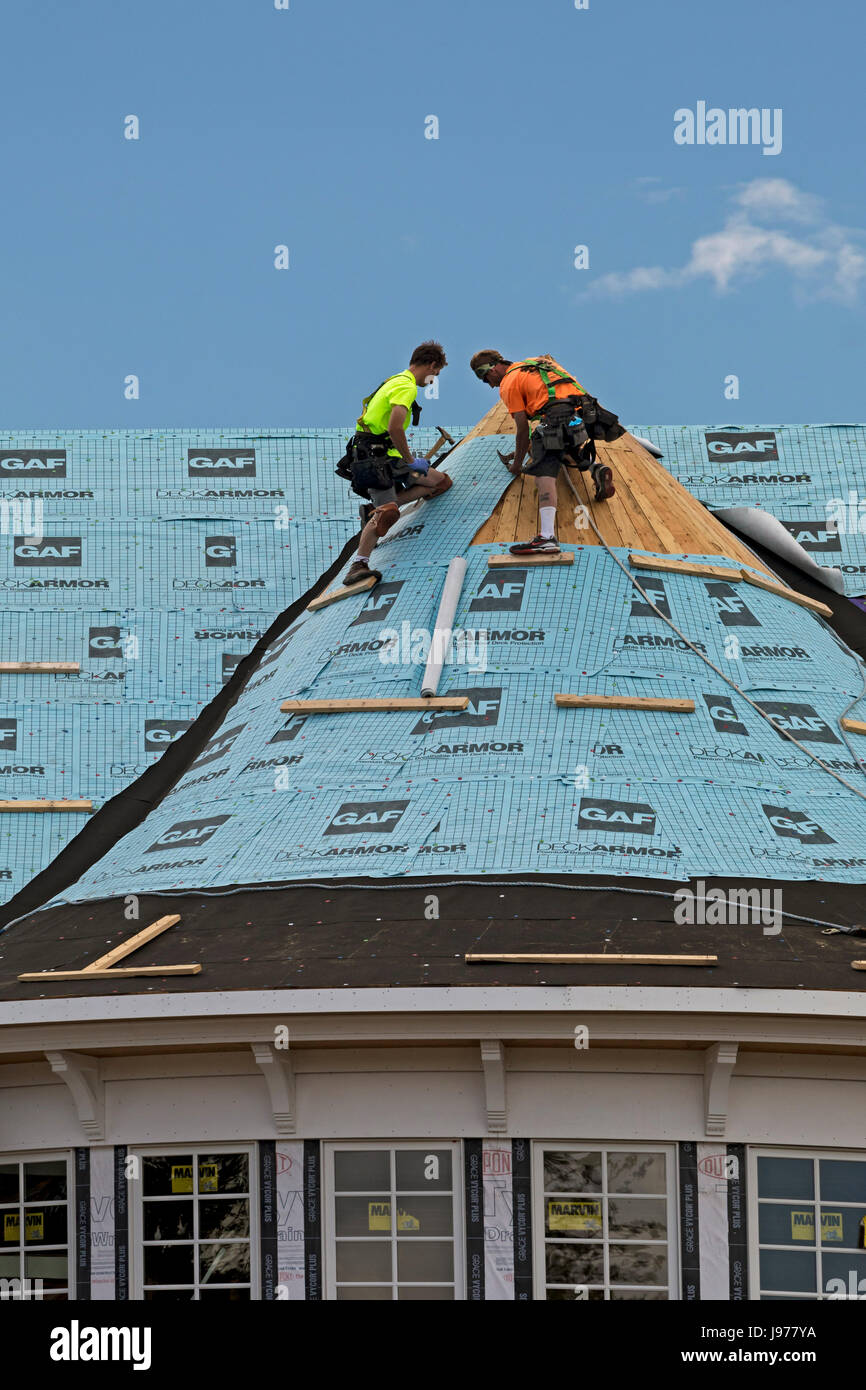 Grosse Pointe Park, Michigan - Workers install synthetic roofing felt on a mansion under construction on the shore of Lake St. Clair. Stock Photo