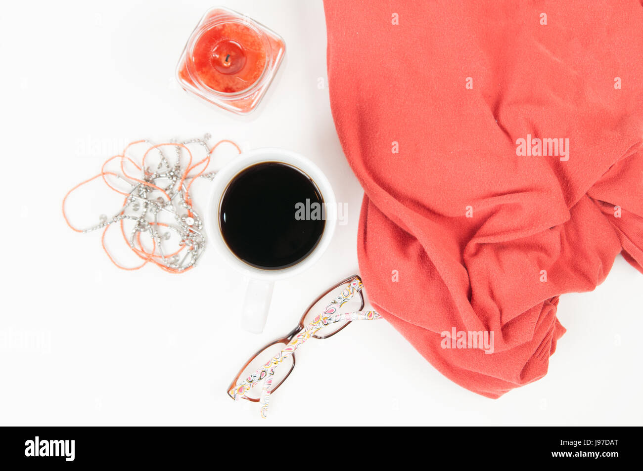 Feminine Flat Lay of coffee, candle, glasses, blanket and necklace on a white background Stock Photo