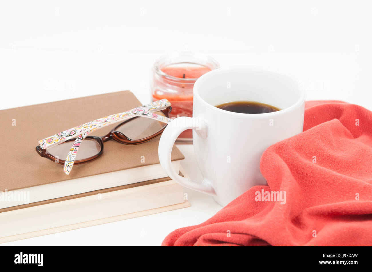 White desk top with various items on it with pops of orange colour Stock Photo