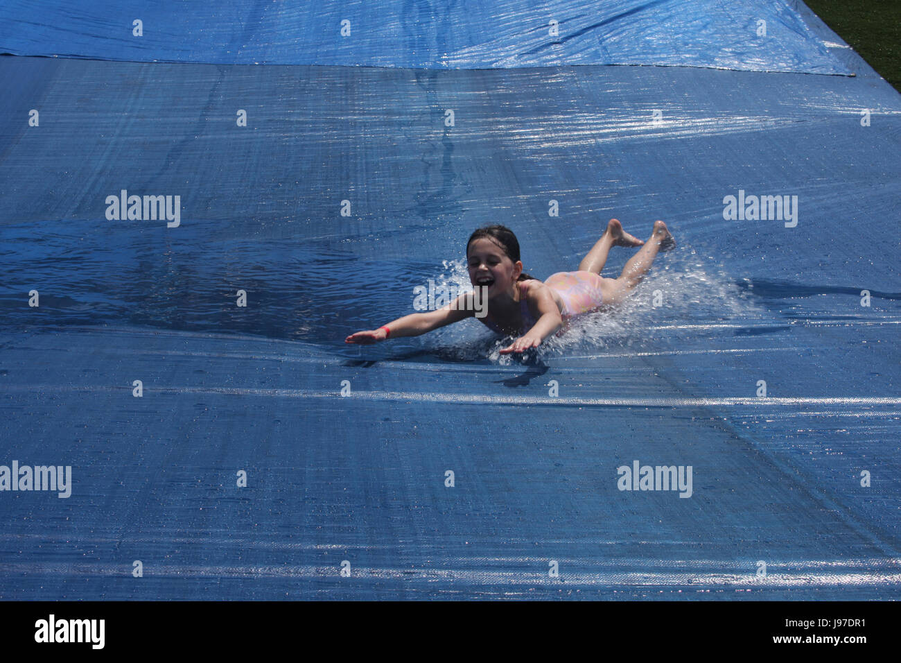 Happy girl on water slide Stock Photo - Alamy