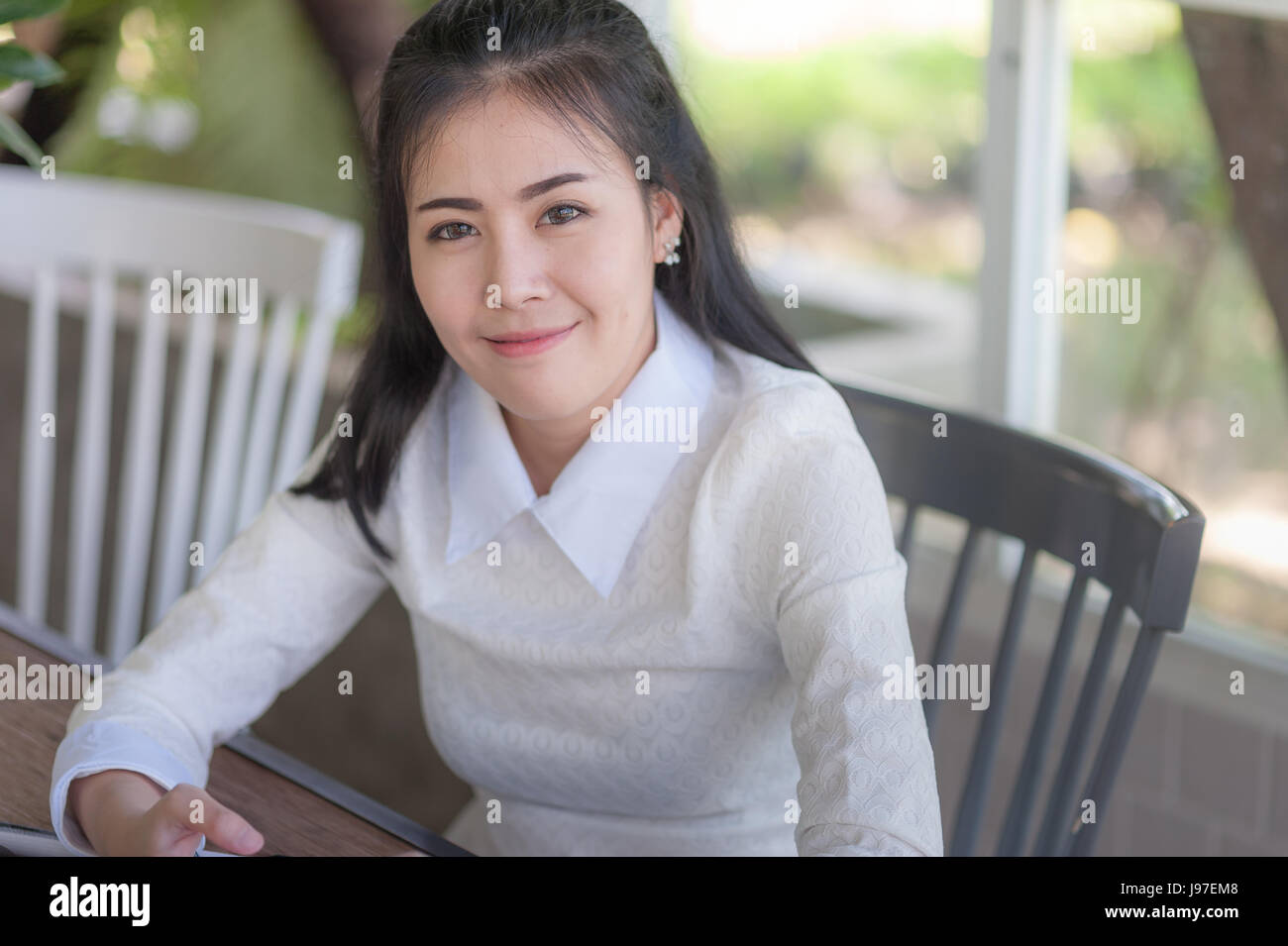 Young attractive Asian woman smiling while sitting in cafe. Cute girl with  hapiness feeling concept Stock Photo - Alamy