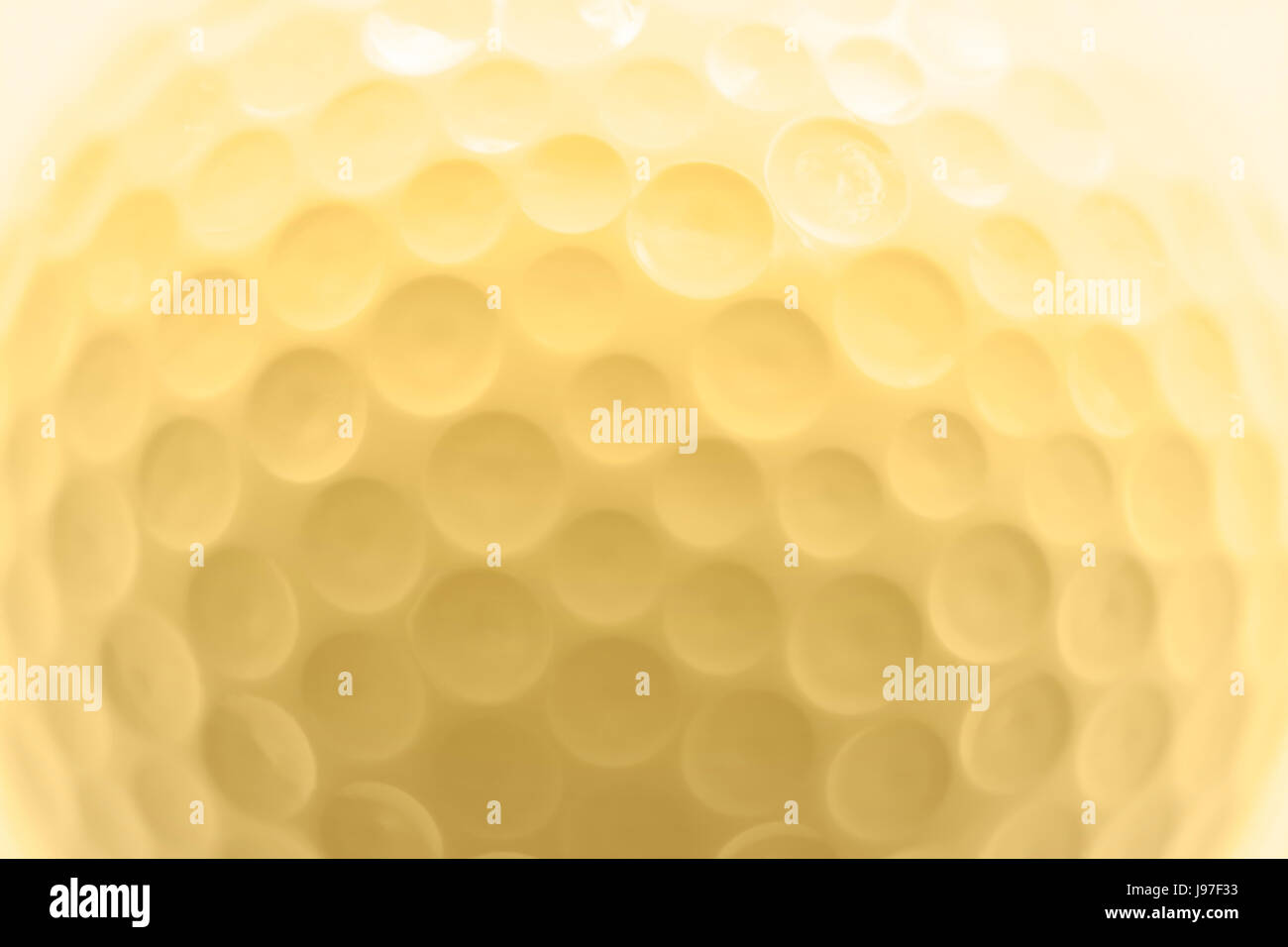 Golf ball texture, macro photography, soft golden color effect. Stock Photo