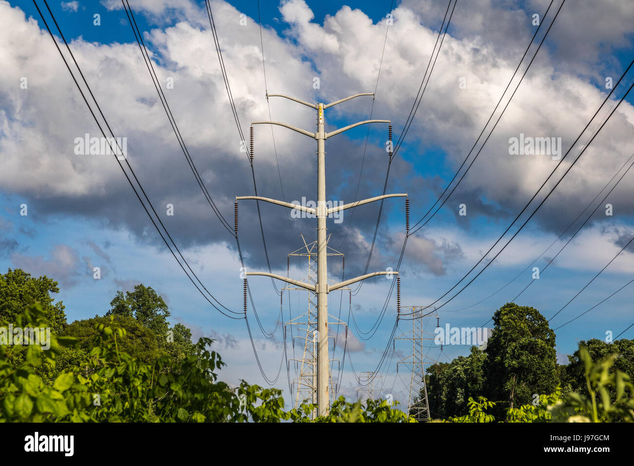 Horizontal photo of power lines and tower against a blue sky with large ...