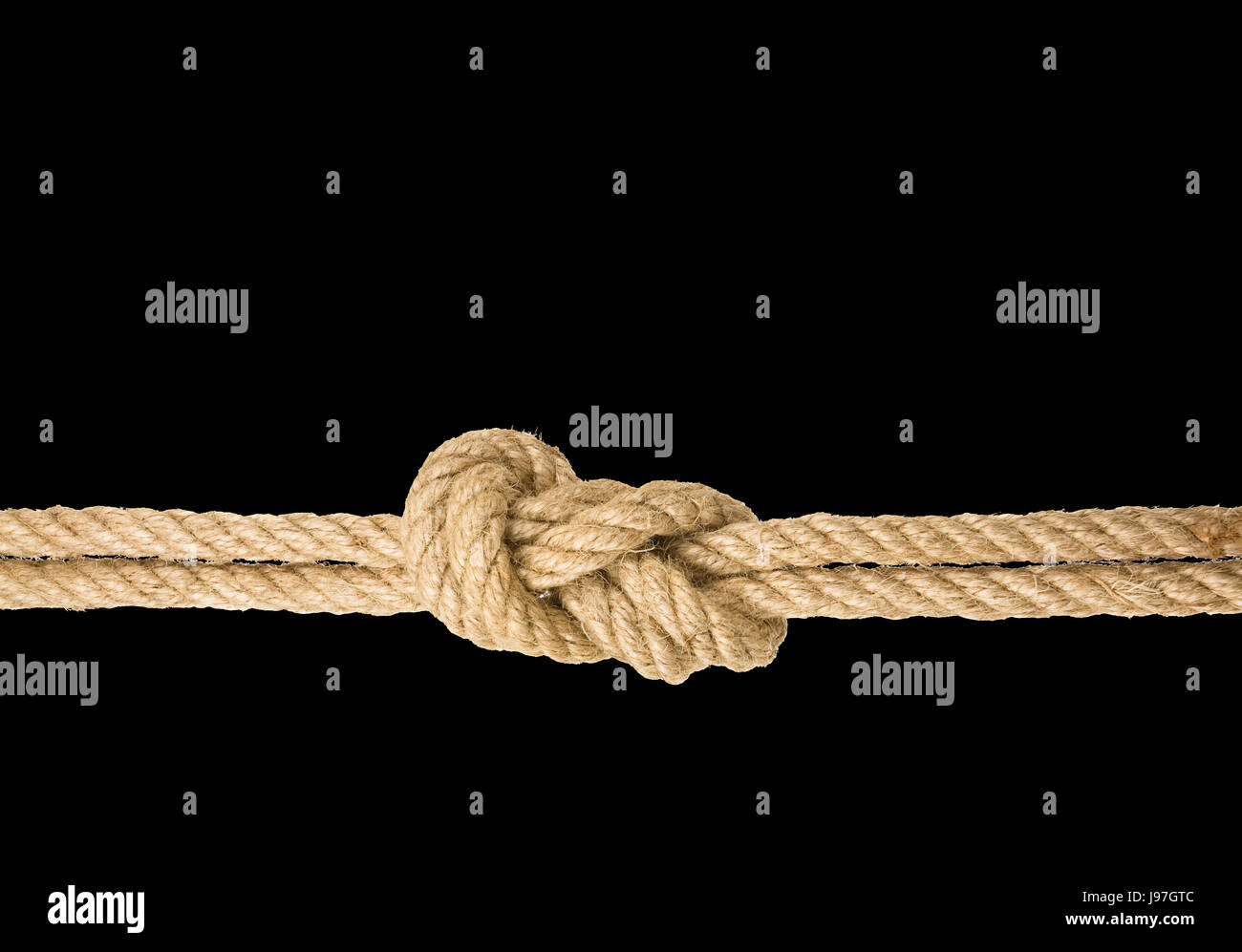 Strong rope with a knot, isolated against the black colored background Stock Photo
