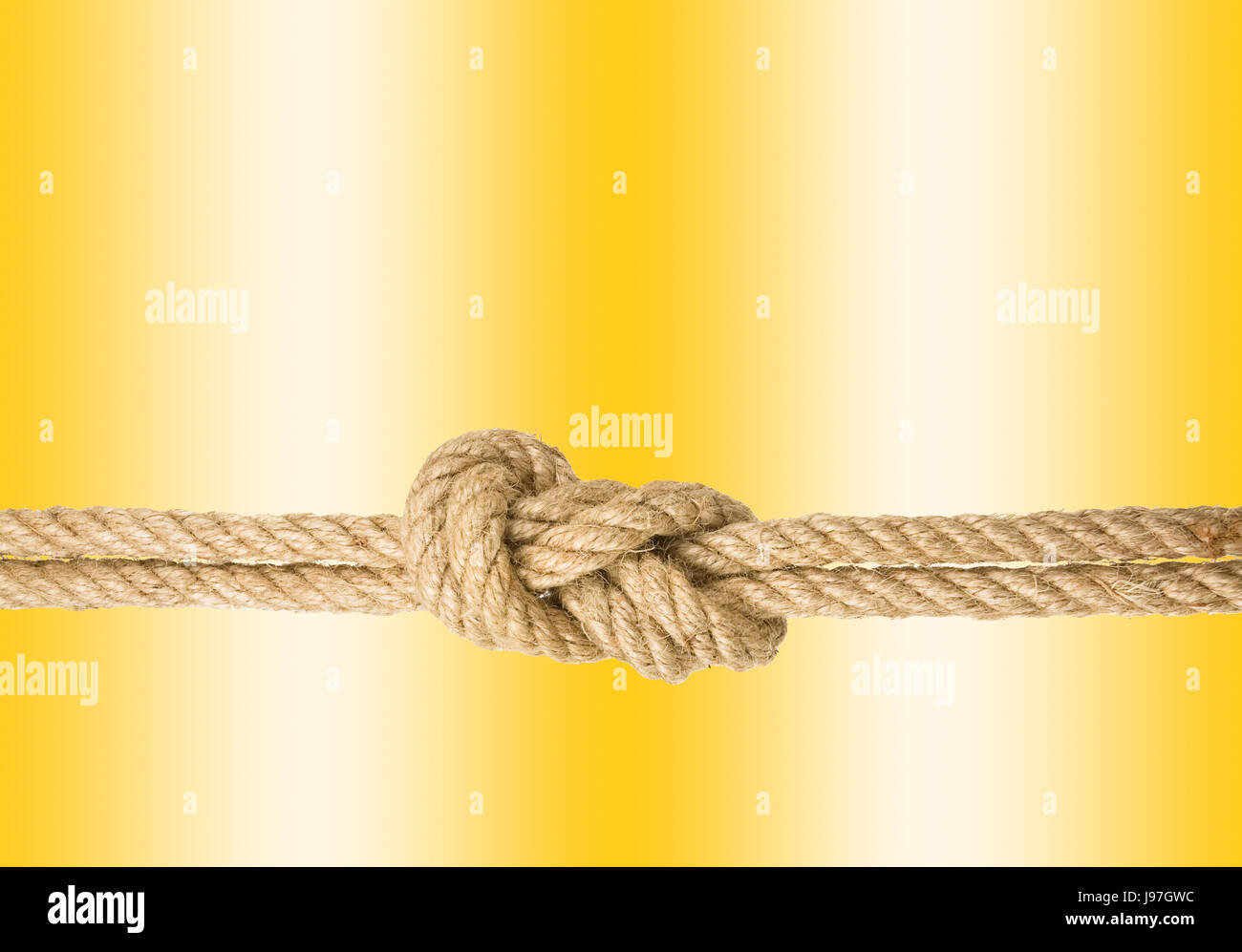 Strong rope with a knot, isolated against the golden colored background Stock Photo