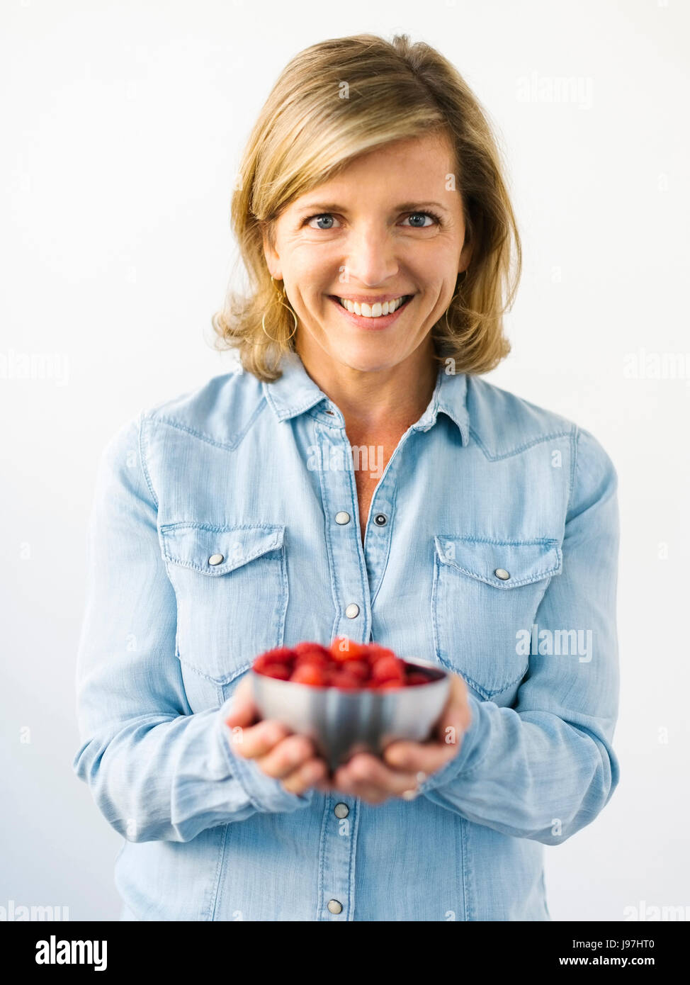 Portrait of Mature woman holding bowl with raspberries Stock Photo - Alamy