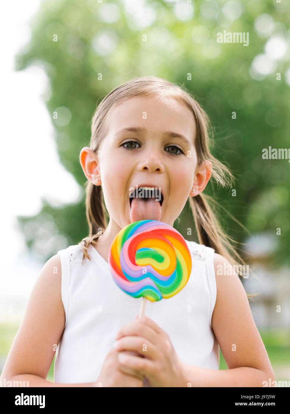 Girl (4-5) licking colorful lollipop Stock Photo