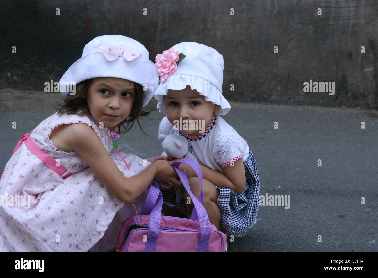 Two little girls fashionably dressed, alone on the street Stock Photo