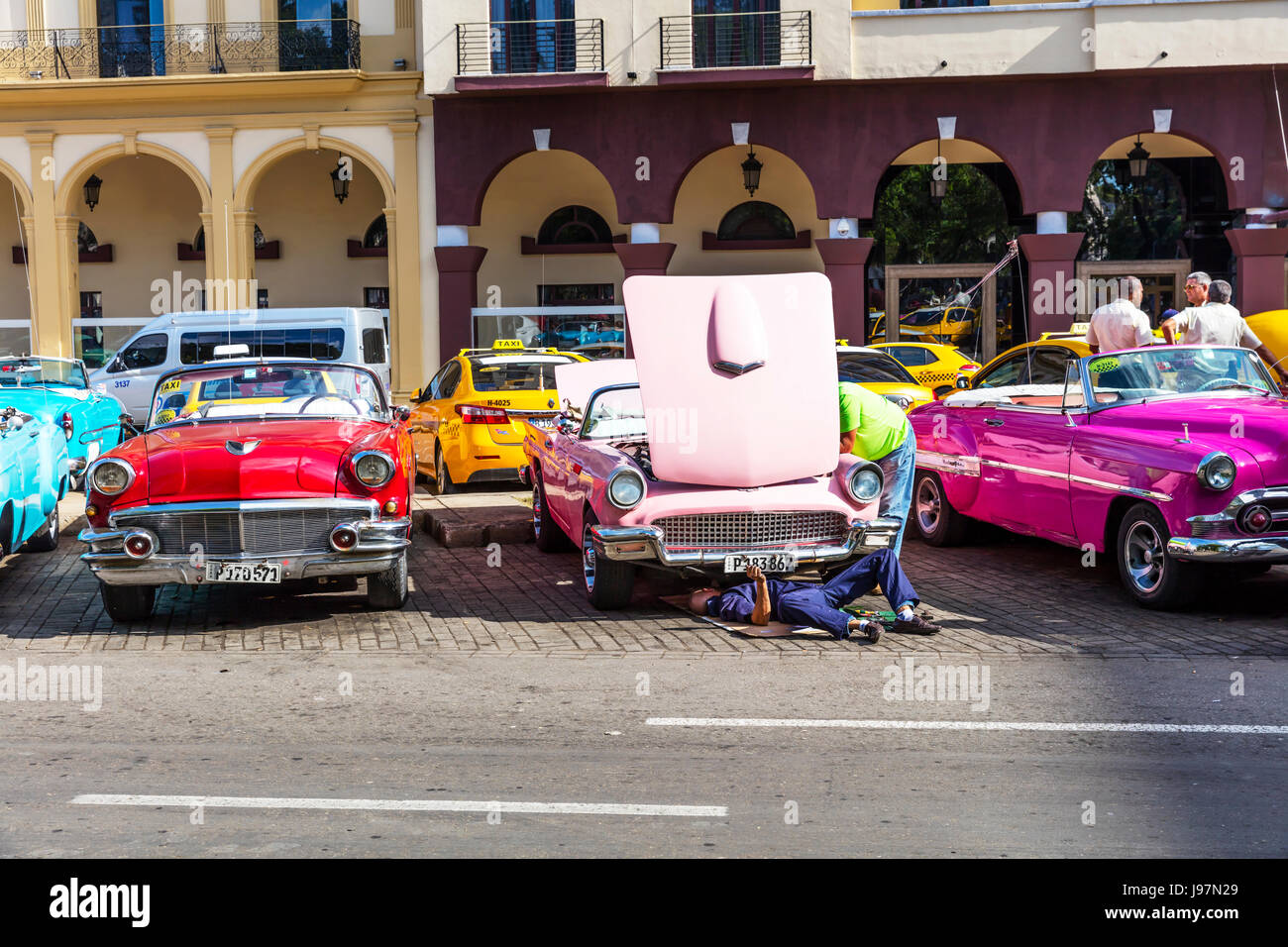 Repairing old classic pink Chevrolet car, Havana cuba, Cuban car, Bonnet up, car needing repair, car trouble, underneath car, mending car, Stock Photo