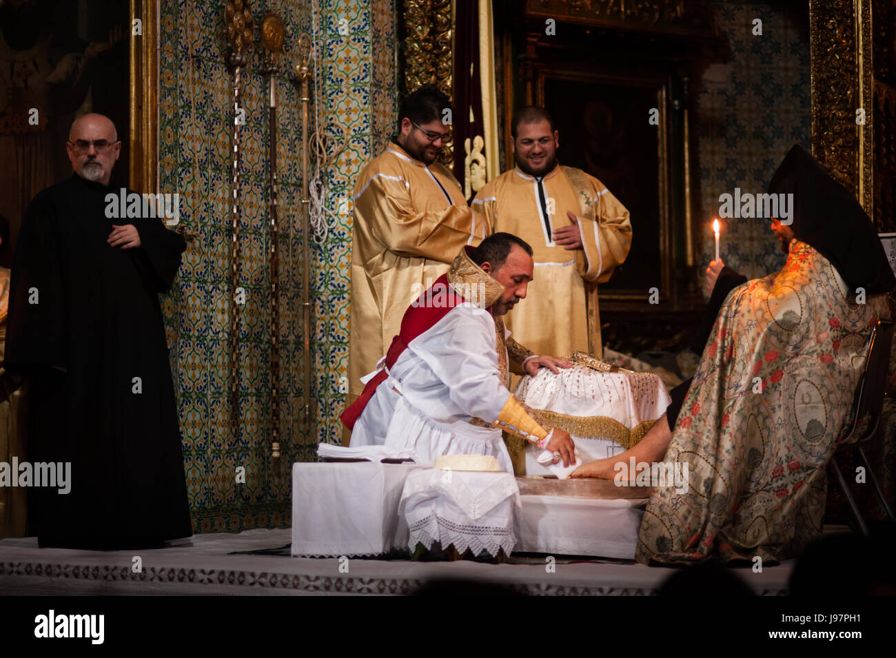 Armenian Patriarch of Jerusalem, Nourhan Manougian, washes the feet of fellow clergy during a special Maundy Thursday mass in the Cathedral of St. James in the Old City of Jerusalem, April 17, 2014. The ritual commemorates Jesus' washing of his disciples feet after the Last Supper, the night brefore his arrest and crucifixion. Stock Photo