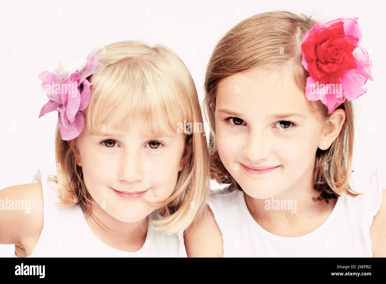 Children sitting, two girls with bobs, bob hairstyles and flowers in their  hair Stock Photo - Alamy