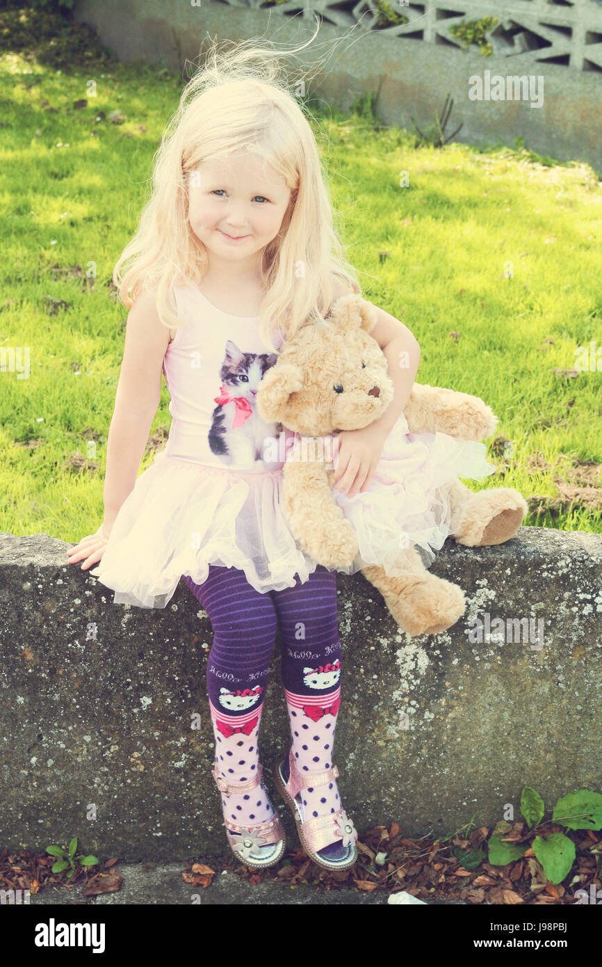 Little three year old girl , child with long curly blonde hair sitting wall  child holding, with her matching teddy bear little blonde girl Stock Photo  - Alamy
