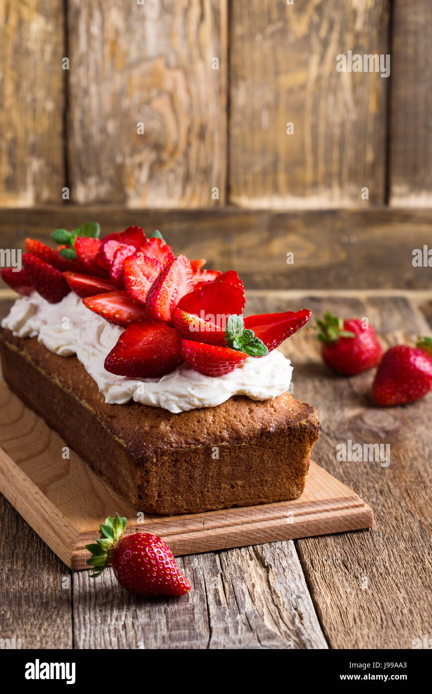 Strawberry and cream cheese summer cake on wooden board. Homemade
